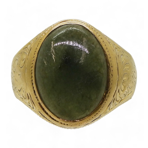 723 - A bright yellow metal signet ring, stamped 90% set with a green hardstone, with engraved shoulders, ... 