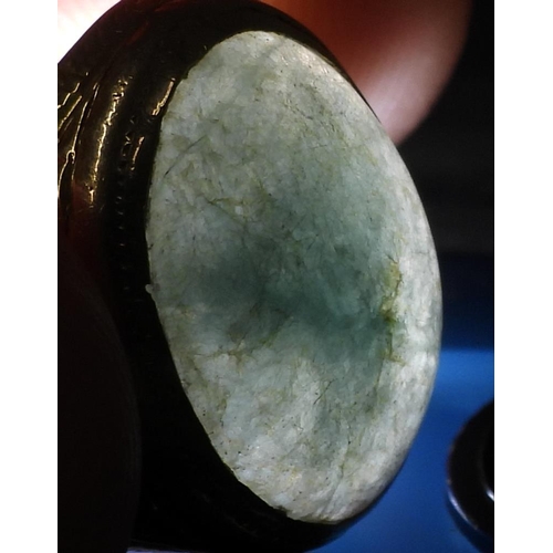 723 - A bright yellow metal signet ring, stamped 90% set with a green hardstone, with engraved shoulders, ... 