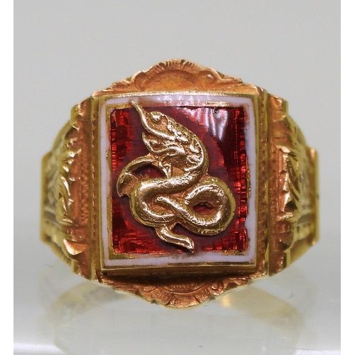 726 - A bright yellow metal ring, with enamelled panel of a serpent, stamped 90% with further Chinese char... 