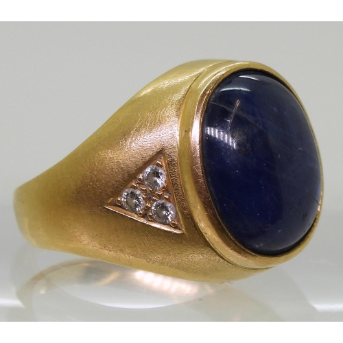 728 - A bright yellow metal ring set with a large opaque sapphire set with estimated approx 0.18cts of bri... 