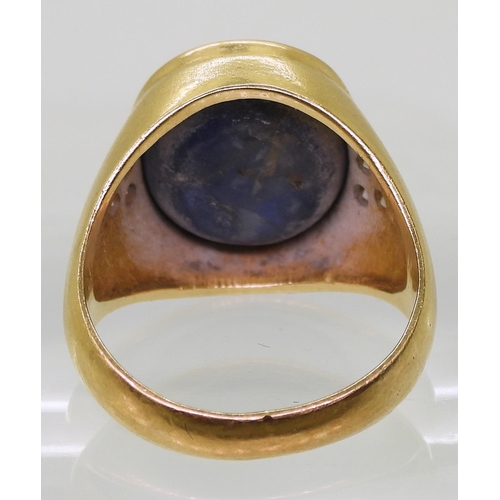 728 - A bright yellow metal ring set with a large opaque sapphire set with estimated approx 0.18cts of bri... 