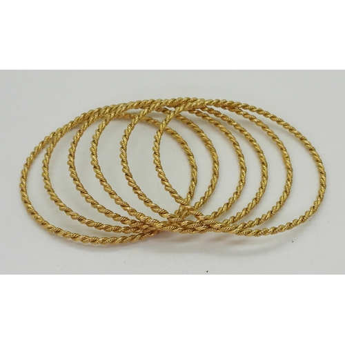 748 - A set of six bright yellow metal bangles from Iran, weight all together 63.1gms