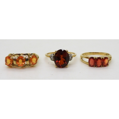 758 - Three 9ct gold gem set rings. A dark orange and clear gem, size Q, together with an orange gem, (pos... 