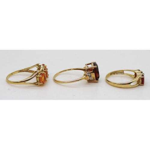 758 - Three 9ct gold gem set rings. A dark orange and clear gem, size Q, together with an orange gem, (pos... 