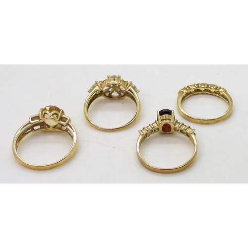 771 - Four 9ct gold gem set rings, clear and purple gem set ring, size N1/2, a yellow sapphire five stone ... 