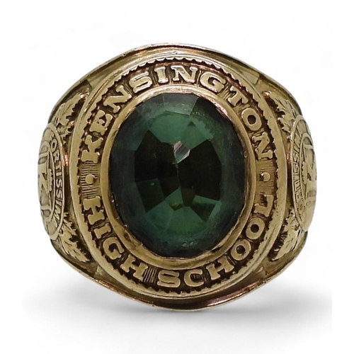 809 - A 10k gold Metal Arts Brand American College ring, Kensington High School 1965, set with a green gla... 