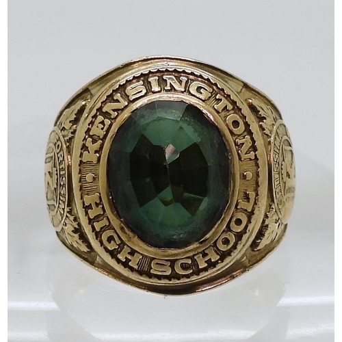 809 - A 10k gold Metal Arts Brand American College ring, Kensington High School 1965, set with a green gla... 