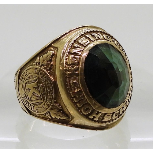 809 - A 10k gold Metal Arts Brand American College ring, Kensington High School 1965, set with a green gla... 