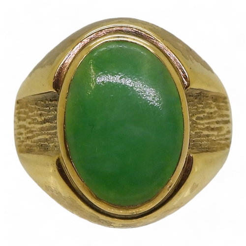 825 - A bright yellow metal ring stamped 18k, and set with a Chinese green hardstone of approx 16mm x 11mm... 