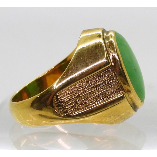 825 - A bright yellow metal ring stamped 18k, and set with a Chinese green hardstone of approx 16mm x 11mm... 