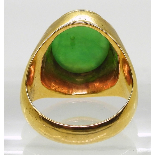 825 - A bright yellow metal ring stamped 18k, and set with a Chinese green hardstone of approx 16mm x 11mm... 