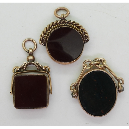 832 - Three 9ct gold carnelian / bloodstone fob seals one with a compass, weigh together 23.7gms 