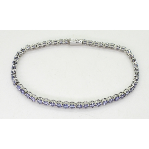 847 - A 18ct white gold tanzanite line bracelet, length 19.5cm, weight 9.5gms