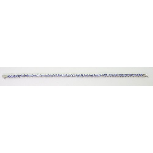 847 - A 18ct white gold tanzanite line bracelet, length 19.5cm, weight 9.5gms