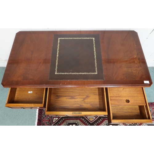 11 - A 20th century mahogany reproduction writing desk with embossed skiver desk top over long central fr... 