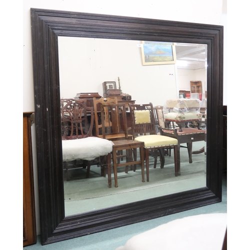 128 - A large stained oak bevelled glass wall mirror, 151cm x 150