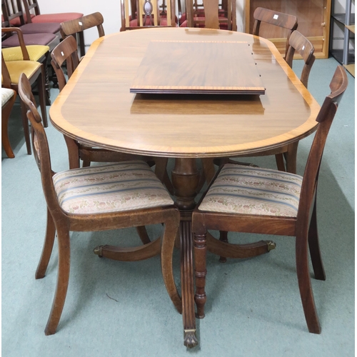 140 - A 20th century mahogany twin pedestal dining table and six chairs, table with two spare leaves on tr... 