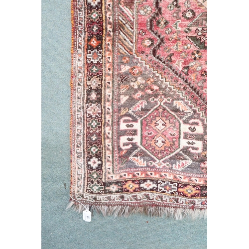 18 - A pink ground Persian Qashqai rug with dark geometric central medallion and matching spandrels on ge... 