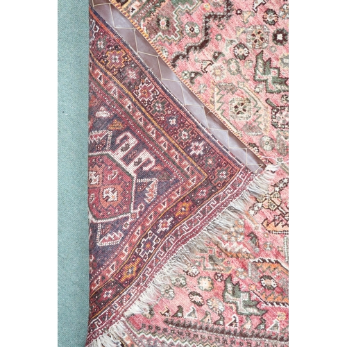 18 - A pink ground Persian Qashqai rug with dark geometric central medallion and matching spandrels on ge... 