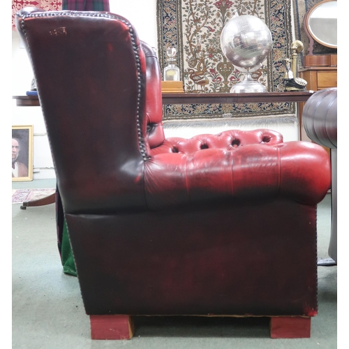 19 - A 20th century oxblood buttonback leather upholstered Chesterfield style wingback armchair, 97cm hig... 