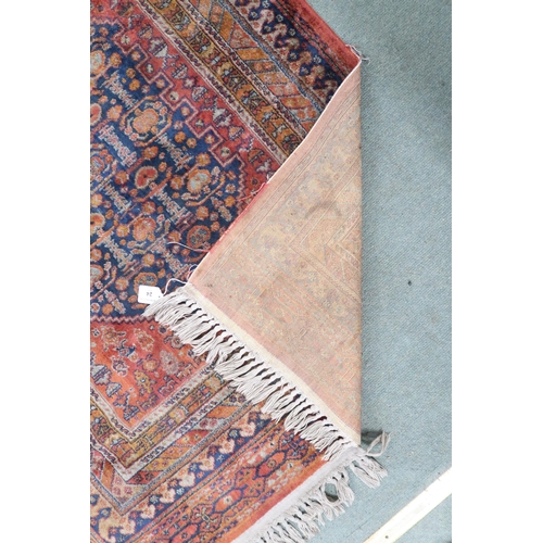 24 - A terracotta ground fine full pile Bijar rug with dark blue geometric central medallion within multi... 