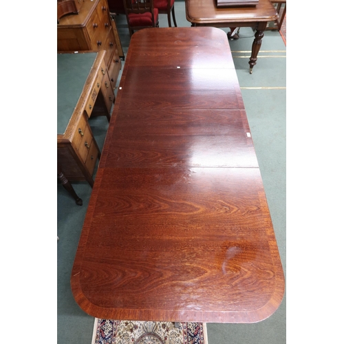 36 - A 20th century cherry veneered twin pedestal dining table with two spare leaves on splayed tripod pe... 