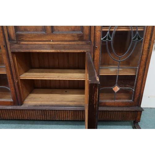 6 - An early 20th century oak bureau bookcase with central panel fall front writing compartment over sin... 