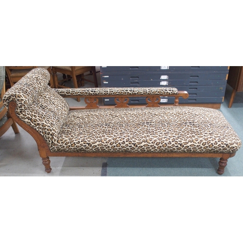 67 - A Victorian oak framed chaise longue with contemporary leopard fabric upholstery on turned supports,... 