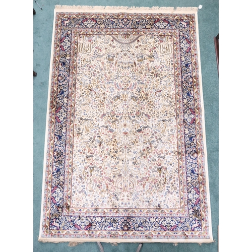 72 - An ivory ground full pile Kashmir tree of life patterned rug, decorated with stylized animals on flo... 