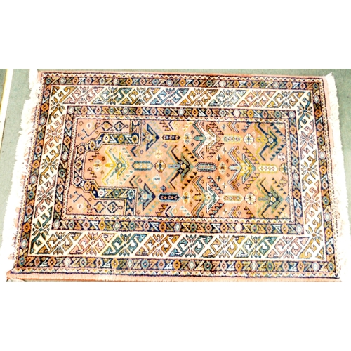 86 - A pink ground Turkish style rug with all-over geometric design within multiple multicoloured geometr... 