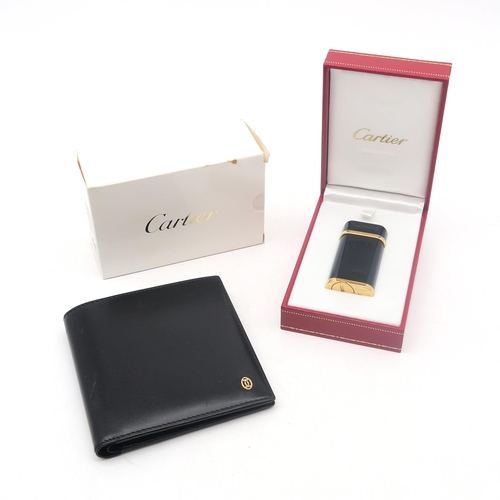 302 - A boxed Cartier cigarette lighter, no. 189022; together with a black bifold wallet stamped 