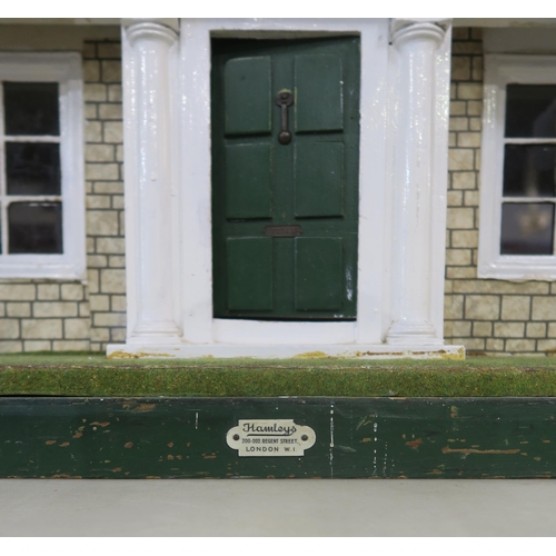 370 - A vintage Hamley's dolls' house, with porticoed front entrance, the hinged frontage opening to revea... 