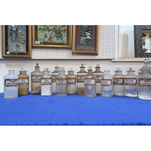 184 - A collection of 33 clear glass chemists jars, most with stoppers and white and gilt glass labels