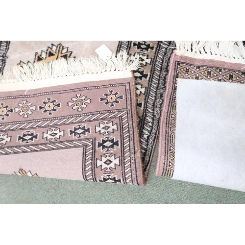 29 - A lot comprising a mauve ground Bokhara style rug, 132cm long x 78cm wide and another beige ground P... 