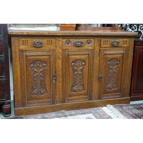 34 - An early 20th century oak Arts & Crafts sideboard with three drawers over three cabinet doors al... 