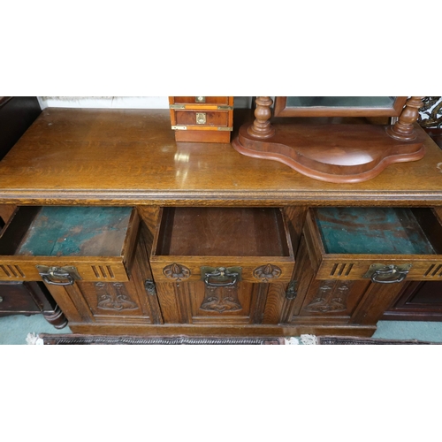 34 - An early 20th century oak Arts & Crafts sideboard with three drawers over three cabinet doors al... 