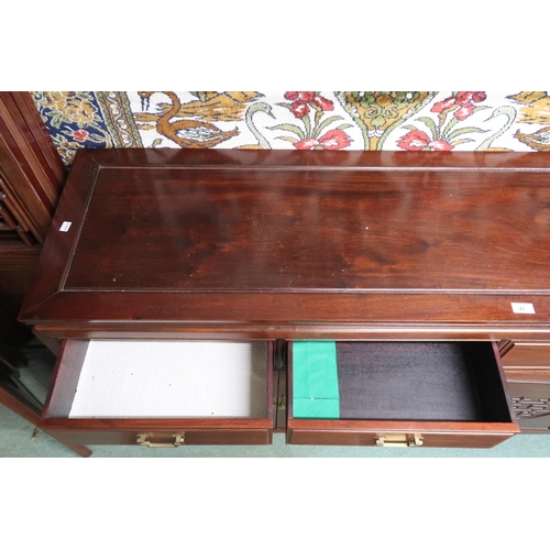 41 - A 20th century Chinese hardwood sideboard with four drawers with brass drawer pulls over four carved... 