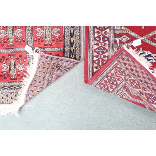 44 - A lot comprising a small red ground geometric patterned rug, 72cm long x 60cm wide and another red g... 