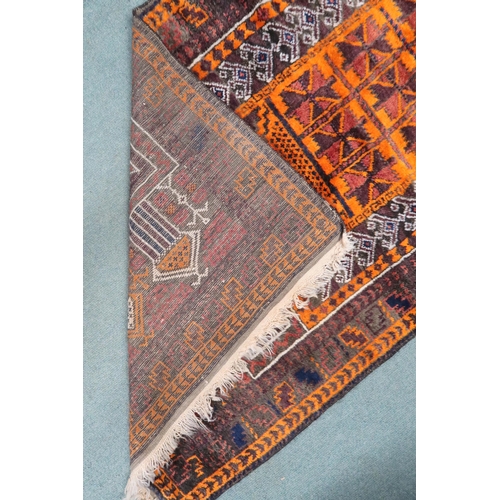 5 - A burnt orange dark ground eastern geometric patterned prayer rug, 157cm long x 91cm wide 