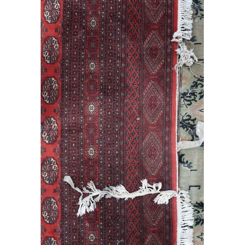 52 - A large red ground Pakistani Bokhara style rug with allover lozenge patterned ground within geometri... 