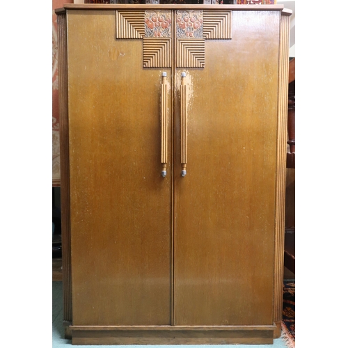 63 - An early 20th century oak Wylie & Lochhead Art Deco style two door cabinet with fruit on the vin... 