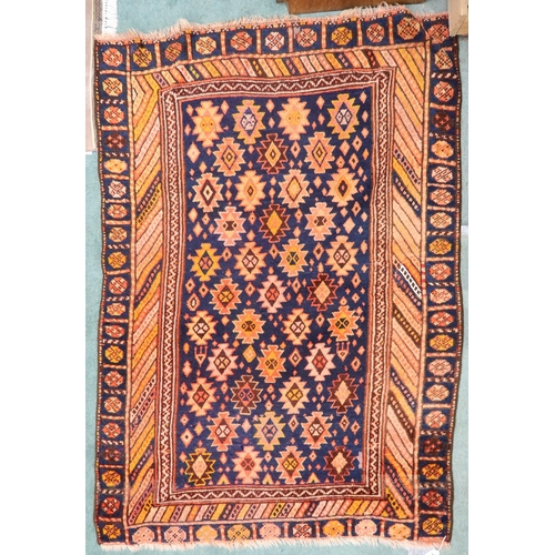 65 - A dark blue ground Persian Qashqai rug with burnt orange geometric pattern within burnt orange borde... 