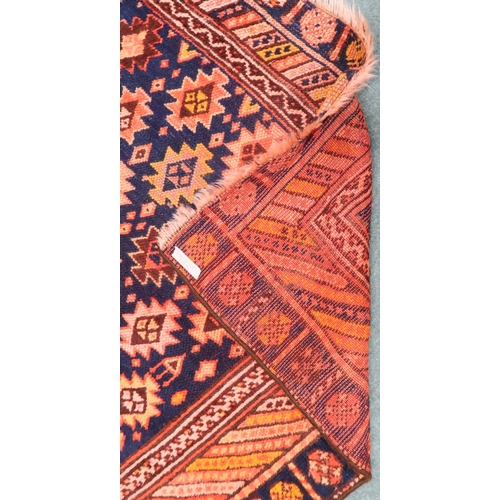 65 - A dark blue ground Persian Qashqai rug with burnt orange geometric pattern within burnt orange borde... 