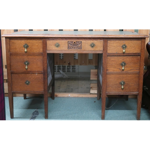 70 - A 20th century oak desk with central long drawer flanked by banks of three drawers on square taperin... 