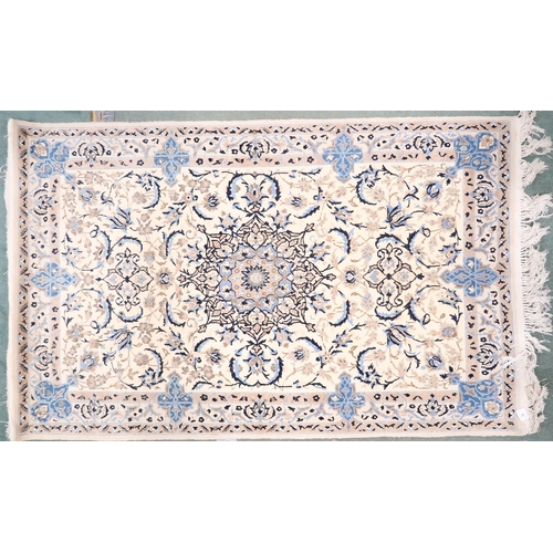 76 - An ivory ground Tabriz rug with dark blue sunburst central medallion on floral patterned ground with... 