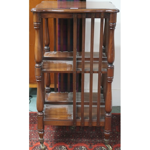 78 - A 20th century mahogany two tier four sided open bookcase on turned supports terminating in casters,... 