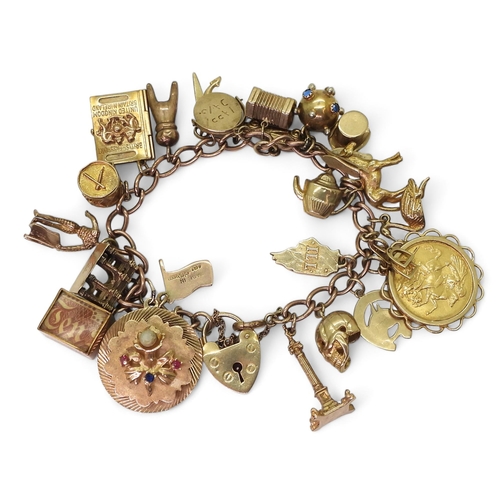 A 9ct gold charm bracelet, with a 1911 full gold sovereign in 9ct pendant mount, nineteen 9ct charms to include a skull, Georg Jensen St. Christopher, drum with hidden bugle player, three 14k charms the largest approx 5.9gms, and two yellow metal charms total weight all together 64.8gms