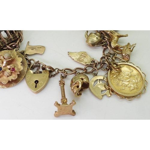 750 - A 9ct gold charm bracelet, with a 1911 full gold sovereign in 9ct pendant mount, nineteen 9ct charms... 