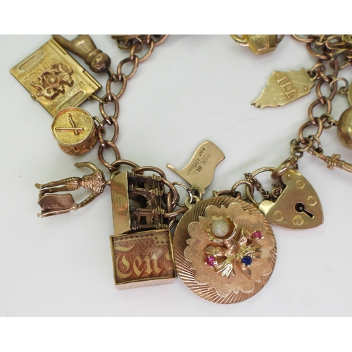 750 - A 9ct gold charm bracelet, with a 1911 full gold sovereign in 9ct pendant mount, nineteen 9ct charms... 