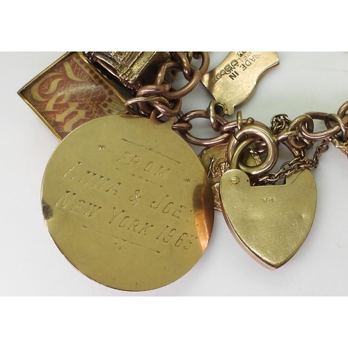 750 - A 9ct gold charm bracelet, with a 1911 full gold sovereign in 9ct pendant mount, nineteen 9ct charms... 